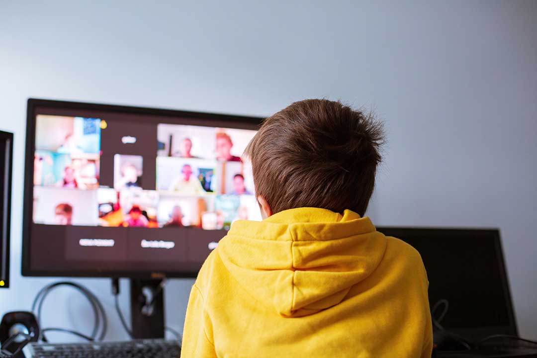 Boy facing computer screen during zoom class session.